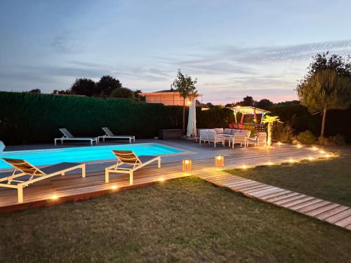 une arrière-cour avec une piscine bordée de chaises et de lumières dans l'établissement Arès, Villa Mapouchet, piscine, à Arès
