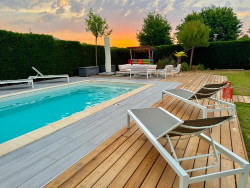 a deck with chairs and a swimming pool at Arès, Villa Mapouchet, piscine in Arès