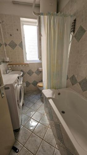 a bathroom with a tub and a toilet and a sink at Amasing view from the White terrase in Baška