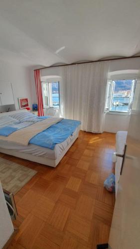 a large bedroom with a bed and two windows at Amasing view from the White terrase in Baška