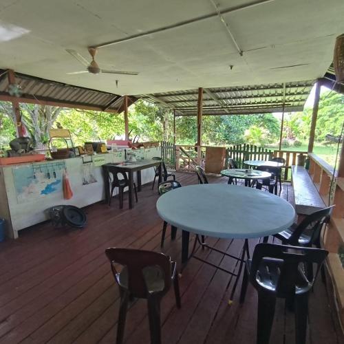 a patio with tables and chairs on a deck at Kinabalu Poring Vacation Lodge in Kampung Poring