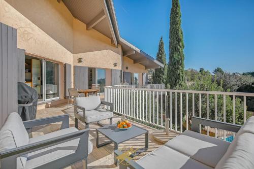 a patio with chairs and a table on a balcony at Maison de la Pointe - 4 etoiles - Vue mer - Piscine - Rayol Canadel in Rayol-Canadel-sur-Mer