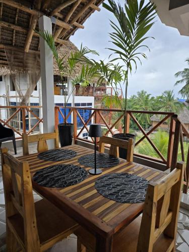 a wooden table on the balcony of a house at Smile Boutique Beach hotel in Nungwi