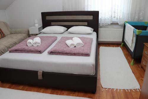 a bedroom with a bed with two white slippers at Holiday Home Peaceful Retreat in Visoko