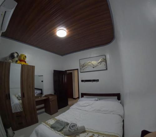 a small bedroom with a bed and a mirror at Spacious Home with Great Location in Panabo City in Panabo