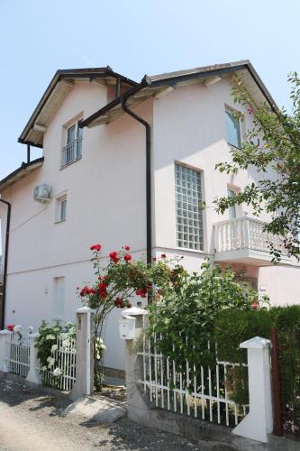 a white house with a white fence and red flowers at Holiday Home Peaceful Retreat in Visoko