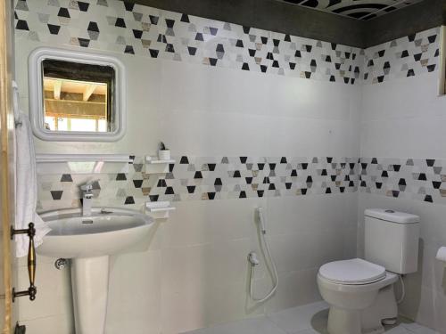 a white bathroom with a sink and a toilet at Mayon Resort Gulmit in Gulmit
