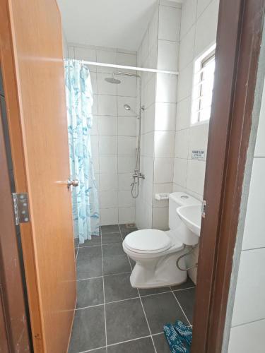 a bathroom with a toilet and a shower at Aruna Retreat Rawang in Rawang