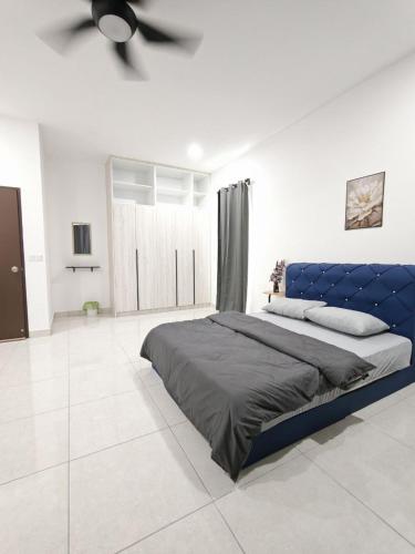 a bedroom with a blue bed and a ceiling fan at Aruna Retreat Rawang in Rawang