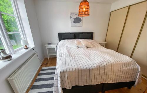 a bedroom with a bed and a pendant light at 3 Bedroom Awesome Home In Kalmar in Böda