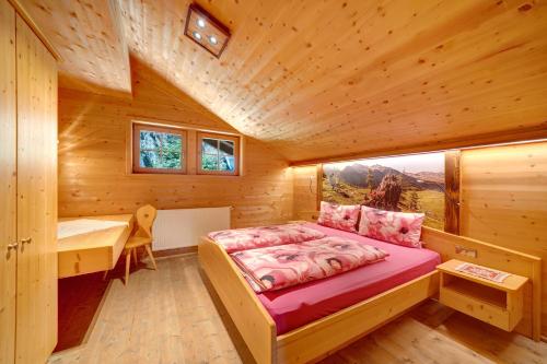 a bedroom in a log cabin with a bed and a desk at Unterjochmayrhof in Ultimo