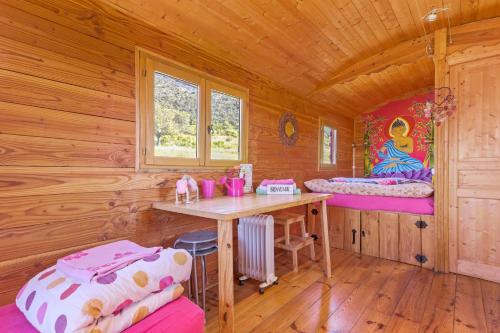 a wooden cabin with a desk and a table at Roulotte Ferme Saint-Pierre in Bargème