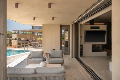 a living room with a couch and a tv and a pool at Villa Portokalea in Maleme