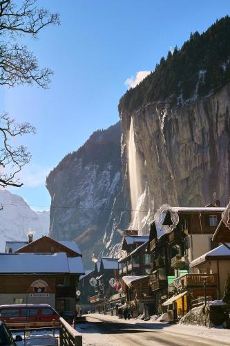 a town with a waterfall on the side of a mountain at Studio 104 - Riverside in Interlaken
