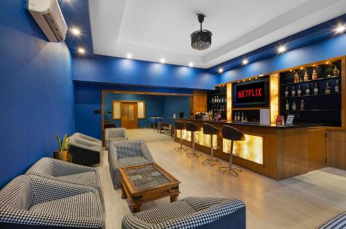 a bar with blue walls and chairs in a room at Alaya Stays Jeevantara by ELIVAAS in Udaipur