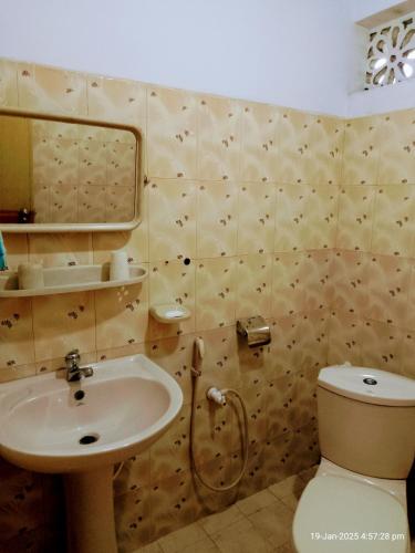 a bathroom with a sink and a toilet at Ima Apartment in Galle