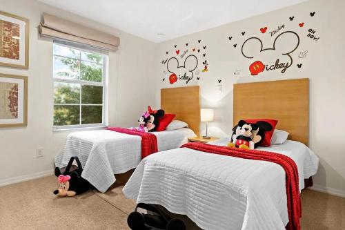 two beds in a bedroom with hello kitty decals on the wall at Spectacular House with 3BR - Private Pool, BBQ - Minutes from Disney! in Kissimmee