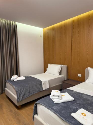 two beds in a hotel room with towels on them at Maper in Pogradec
