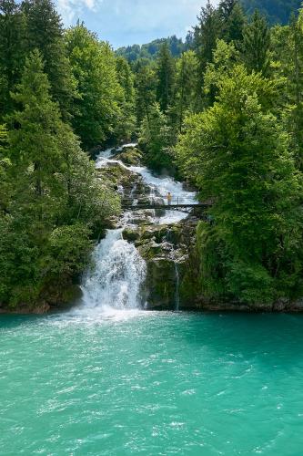 a waterfall in the middle of a river at Brienzersee - Direct lake view in Brienz