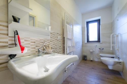 a white bathroom with a sink and a toilet at Agriturismo Tenuta Umberto I in Ripacorbaria