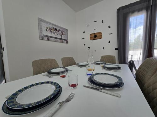 a white table with plates and glasses on it at La Villa di Alice in Vignacastrisi