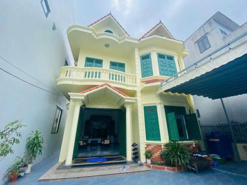 ein großes gelbes Haus mit einer Veranda und einem Balkon in der Unterkunft MoonNest vila catba in Cát Bà