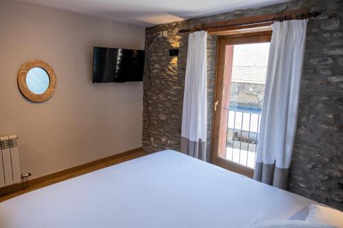 a bedroom with a large bed and a window at Cal Marrufès in Puigcerdà