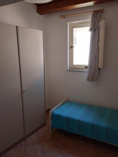 a small bedroom with a bed and a window at Da Massimo in Cefalù