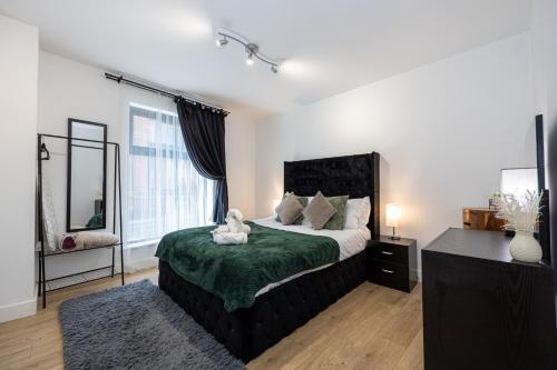 a bedroom with a bed with a teddy bear on it at Stylish 2-Bed Apartment in Manchester City Centre in Manchester