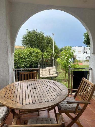 a wooden table and chairs on a patio at villa Alcudia SMIR 3 chambre fnedeq restinga tetoin in Fnidek