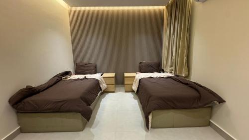 two beds in a small room with a window at شقة بالدور الثالث in Quai