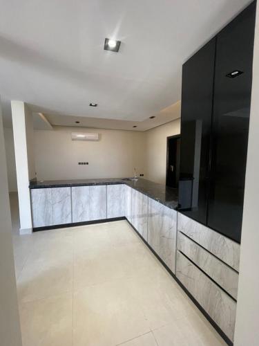 a large kitchen with black and stainless steel cabinets at شقة بالدور الثالث in Quai