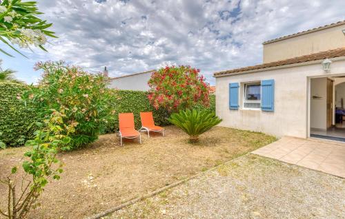 twee oranje stoelen in de achtertuin van een huis bij Nice Home In Saint-Georges-D'oléron in Saint-Georges-dʼOléron