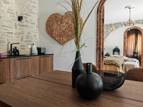 a vase on a table with a heart on the wall at Beauregard Jura - Countryside Estate Stays Near Geneva in Gex