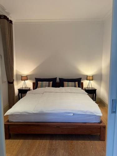 a bedroom with a large white bed with two lamps at Porto Marina Residence in Tivat