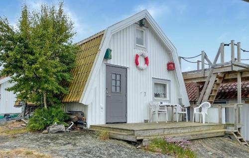 a white building with a porch and a table and chairs at 1 Bedroom Cozy Home In Vrångö in Vrångö