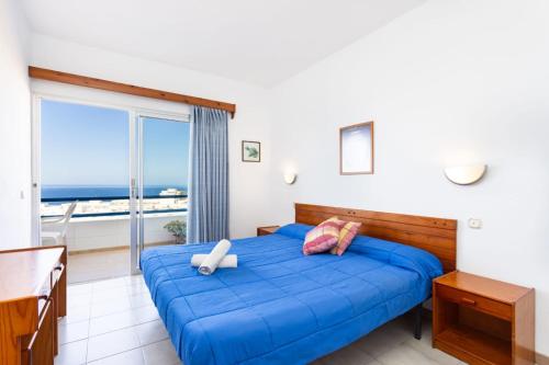 Un dormitorio con una cama azul con vista al mar. en Tenerife View, en Adeje