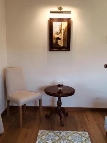 a table and a chair and a picture on a wall at Hotel Foresteria Baglio Della Luna in San Leone