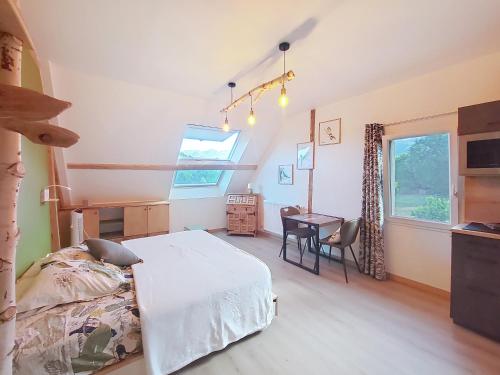 a bedroom with a bed and a table in it at chambre à vold'oiseau in Saint-Sulpice