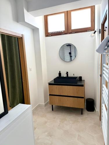une salle de bain avec un lavabo et un miroir dans l'établissement Magnifique Maison rénovée en plein cœur de Sancerre, à Sancerre