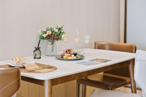 a table with a plate of food and a vase of flowers at Fa万濠国际服务公寓 广州琶洲会展中心店 in Guangzhou