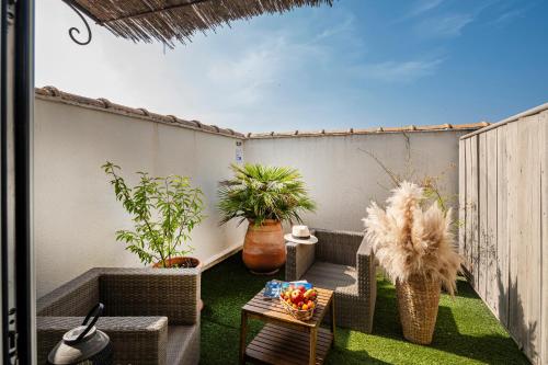 an outdoor patio with chairs and a table and plants at Hôtel de l'Horloge in Avignon