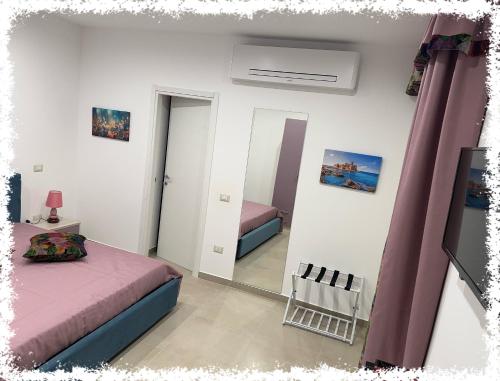 a bedroom with two beds and a mirror at Residence Le Farfalle in Isola Capo Rizzuto
