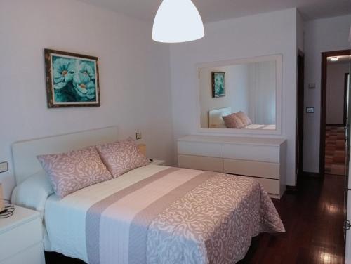 una camera da letto con un letto e un grande specchio di Apartamento en Cee a Cee