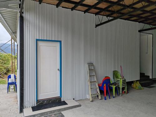 a room with colorful chairs and a white door at Amazing Grace Lodge in Kundasang
