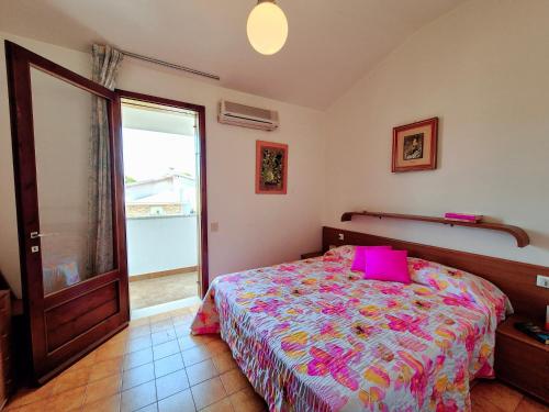 una camera da letto con un letto con un cuscino rosa di Villa Sandra a Bibione