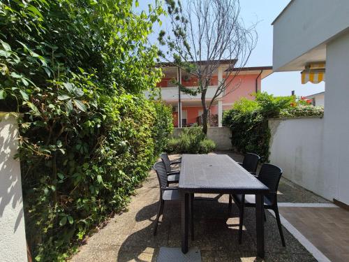 un tavolo e sedie in un giardino con siepe di Villa Sandra a Bibione