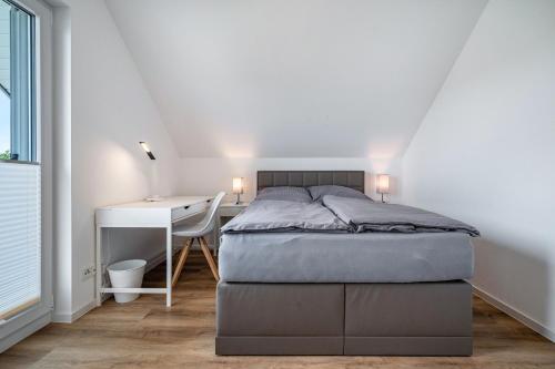 a bedroom with a bed and a desk and a bed and a chair at Seeglück 1 am Tollensesee in Groß Nemerow