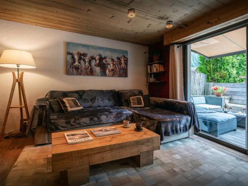 a living room with a couch and a table at Chalet Le Petit Mazot - OVO Network in La Clusaz