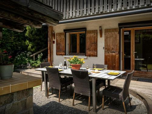 Une table à manger et des chaises sont disponibles sur la terrasse. dans l'établissement Chalet Le Petit Mazot - OVO Network, à La Clusaz